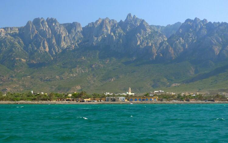 a small coastal village with mountains in the background. a small coastal village with mountains in the background.
